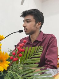 Joel Deva Deva Ezhile presenting at an event with microphone